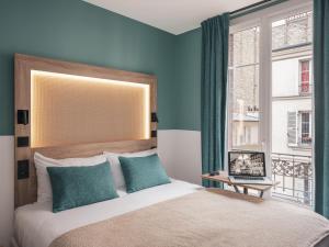 パリにあるイビス スタイルズ パリ モンマルトル ノールのベッドルーム1室(青い壁のベッド1台、窓付)