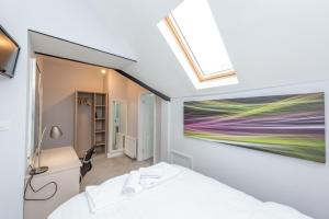 a bedroom with a bed and a painting on the wall at Uno Hotel Heathrow Windsor in Slough