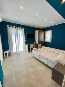 a bedroom with a large bed and a blue wall at Floridida Rooms & Breakfast in Marina di Andora