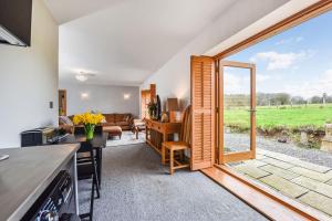uma cozinha e sala de estar com uma grande porta de vidro deslizante em Crabden Meadows, Blendworth em Horndean