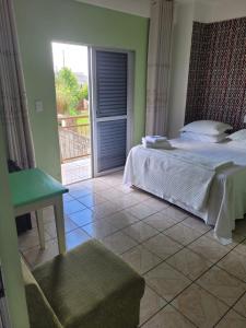 a bedroom with a bed and a sliding glass door at Hotel Duarte in Palmitinho