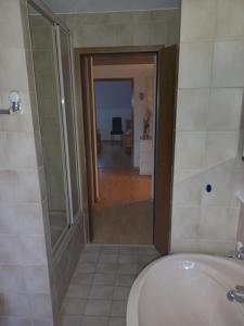 a bathroom with a tub and a toilet and a hallway at Zentrale Ferienwohnung mit Blick auf die Paulinskirche in Trier