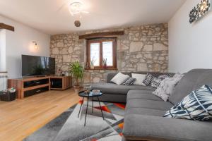 a living room with a couch and a television at Luxury 3 Bedroom Apartment in Vrsar