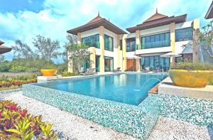 
a large white swimming pool in front of a house at Ataman Luxury Villas SHA Plus in Ko Kho Khao
