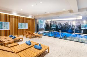 una piscina en una habitación con bancos y una piscina en The Springs Resort & Golf Club, en Wallingford