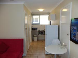 un soggiorno con frigorifero bianco e tavolo di Emu Point Motel a Albany