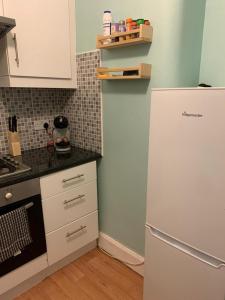 a kitchen with a white refrigerator in a room at Town Centre Kilmarnock in Kilmarnock