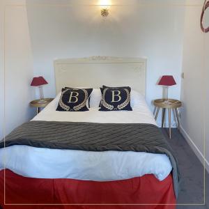 a bed with two pillows on top of it at Hôtel La Batisse in Crémieu