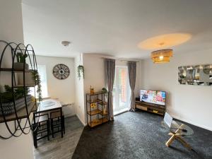 a living room with a tv and a table at Grand Central Littleover Deluxe Apartments in Derby