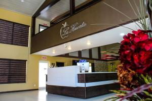 CuauhtémocにあるLa Huerta Inn & Suitesの赤い花のカウンター付きレストランのロビー