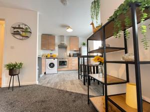 ein Wohnzimmer mit einer Küche und einer Wendeltreppe in der Unterkunft Grand Central Littleover Deluxe Apartments in Derby