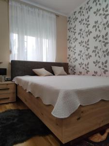 un grande letto in una camera da letto con finestra di Apartman ESPRESSO sa parkingom a Sremska Mitrovica
