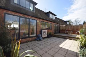a home with a patio and a house at Tabernacle Cottage, Birdham in Birdham