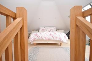 a bedroom with a bed with a pink bedspread at The Barn at Guiles , Petersfield in Petersfield