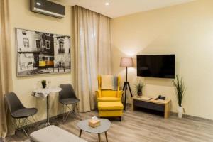 sala de estar con silla amarilla y TV en Malon apartments en Odesa