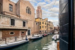 un grupo de barcos en un canal entre edificios en Sogno sull'acqua, en Venecia