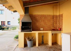 cocina amarilla con encimera y fogones en Casa TAPIOLAS, en Borrassá