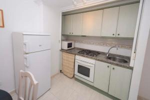 una cucina con frigorifero bianco e lavandino di Topacio i 34b a Calpe