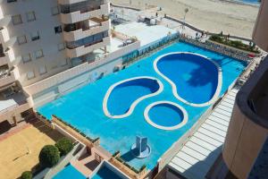 uma vista superior de uma piscina ao lado de um edifício em Topacio i 34b em Calpe