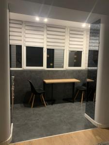 ein Raum mit Tisch und Stühlen und Fenstern in der Unterkunft Квартира в новобудові в районі автовокзал , поруч ТРЦ Арена in Riwne
