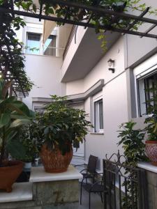 a patio with potted plants and a building at Μονοκατοικία «Maizonette passaggio G» in Volos