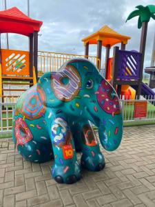 una estatua de elefante de colores frente a un parque infantil en Hotel 10 Itajai/Navegantes, en Itajaí