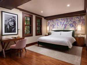 una camera con un grande letto bianco e una scrivania di The Brazilian Court Hotel a Palm Beach