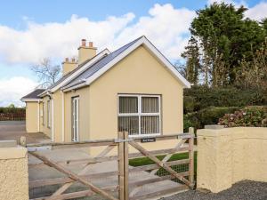 una casa con una puerta de madera delante de ella en Lane Cottage 