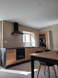 une cuisine avec une table et une cuisinière four supérieur dans l'établissement CLOS SAINT SAUVEUR - guesthouse au coeur des vignes sur le coteau, à Saint-Pierre-dʼAurillac