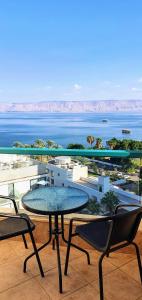 a table and chairs on a balcony with a view of the ocean at Star of Tiberias in Tiberias