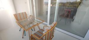 a room with two chairs and a table on a balcony at Casa Mediterranea Jacuzzi riscaldata con Caminetto in Specchiolla