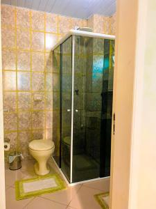 a bathroom with a toilet and a glass shower at Apto lindo e aconchegante próximo a praia in Itapema +1 photo