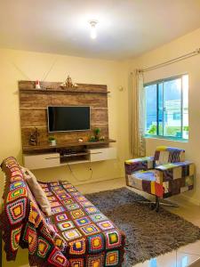 a living room with a couch and a flat screen tv at Apto lindo e aconchegante próximo a praia in Itapema