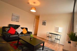 a living room with a couch and a table at Spacious 2Bedroom condo with Patio by Excel Centre in London