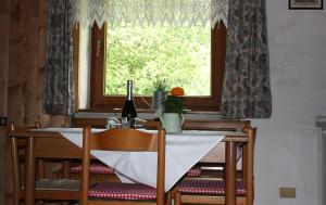 a dining room table with a bottle of wine and a window at Appartamenti Suttru in Badia