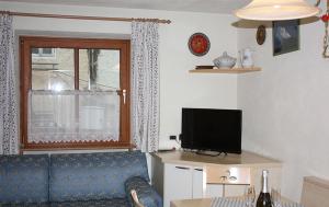 a living room with a blue couch and a television at Appartamenti Suttru in Badia
