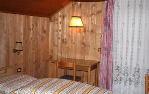 a bedroom with a desk and a bed and a lamp at Appartamenti Suttru in Badia