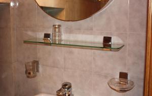 a bathroom with a glass shelf above a sink at Appartamenti Suttru in Badia +63 photos