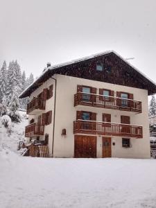 a snow covered apartment building with a balcony at Appartemento Casa Giuli in Passo del Tonale