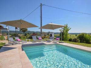 - une piscine avec des chaises longues et des parasols dans l'établissement Villa la Fontaine, à Viré