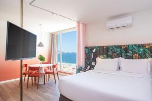 a hotel room with a bed and a view of the ocean at Mercure Rio Boutique Hotel Copacabana in Rio de Janeiro