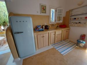 a kitchen with a white refrigerator in a room at Simos suites in Elafonisos
