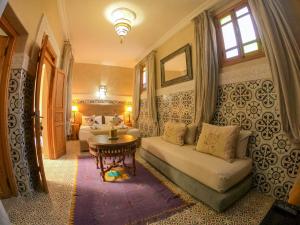 een slaapkamer met een bank en een tafel in een kamer bij Riad Inaka in Marrakesh