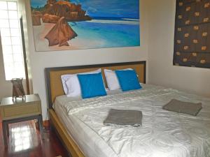 a bedroom with a large bed with blue pillows at Amazing Seaview Villa in Ko Lanta