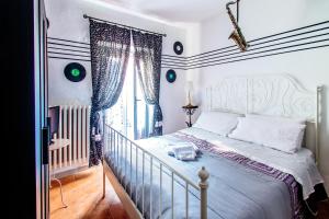 a bedroom with a white bed and a window at La Fabbrica dell'Oro in Asti