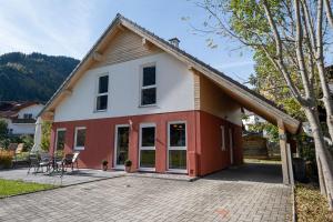 a white and red house with a patio at Alprocks Alvaresort in Bichlbach