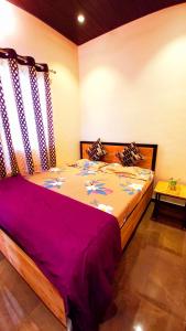 a bedroom with a large bed with a purple blanket at Dadaji Cottage, a unit of DADAJI VILLA in Panchgani