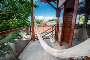 a hammock on the balcony of a house at Estadia Poética in Pipa