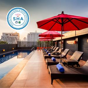 een rij stoelen en parasols op een zwembad op het dak bij Hotel Solo, Sukhumvit 2, Bangkok - SHA Extra Plus in Bangkok