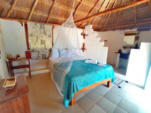 1 dormitorio con 1 cama con mosquitera en Veleando Ando Cabañas en Bacalar